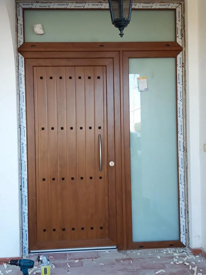 Porta de entrada em alumínio com vidro lateral e bandeira superior